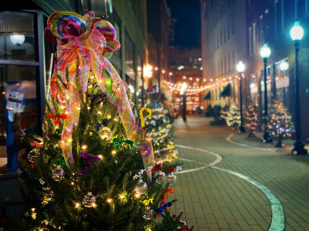 A christmas tree is decorated with colorful ribbons